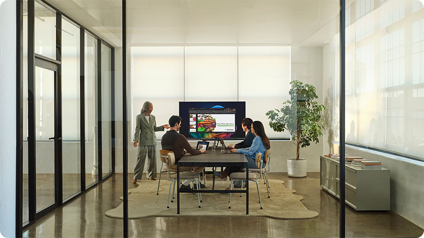 In a Office Space a lady presenting about dentsu and other 3 people watching it.
